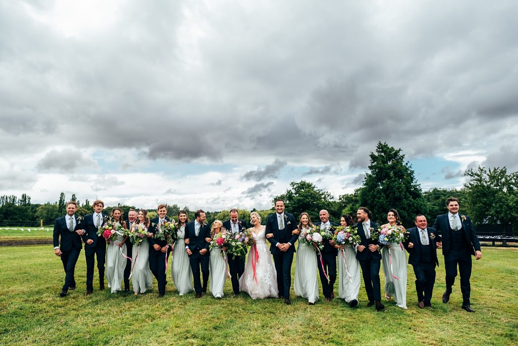 bride groom and wedding party walk toward camera