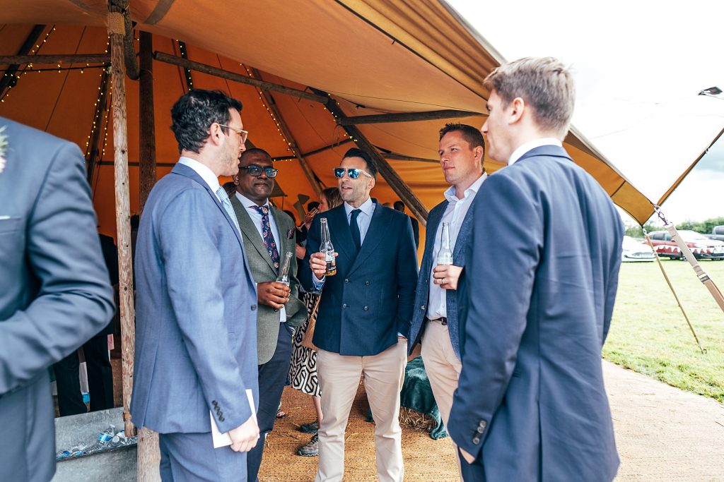 wedding guest chat under open sided tipi