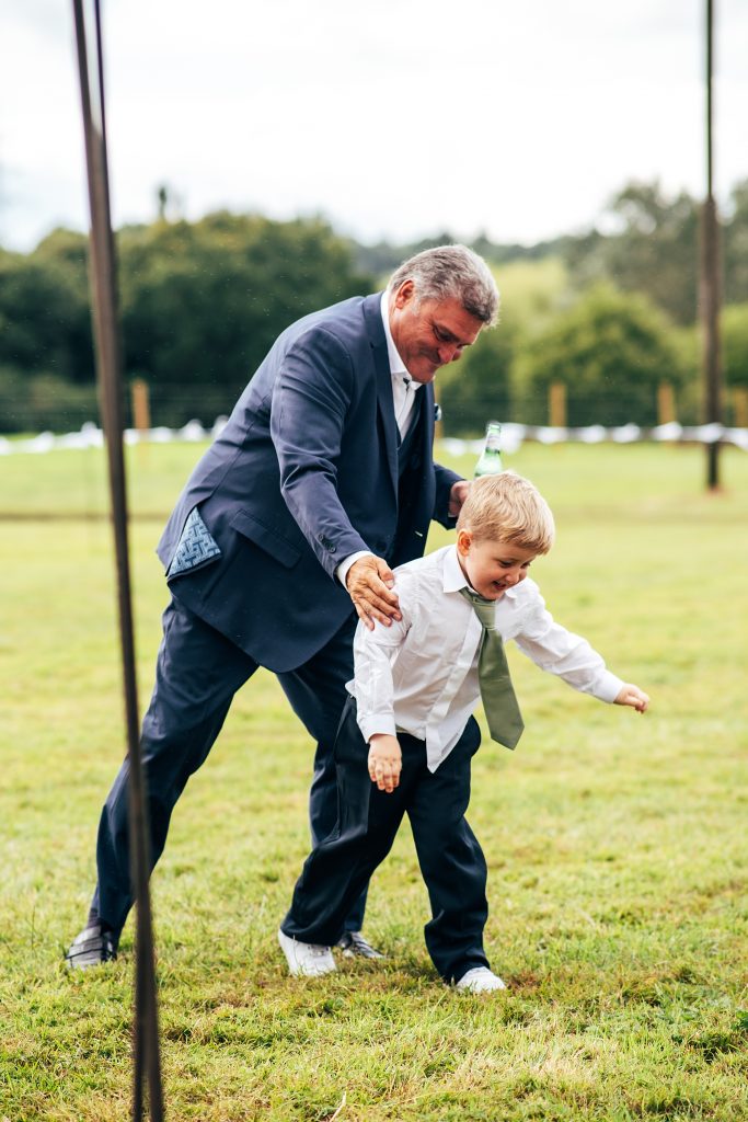 man chases little boy in a field