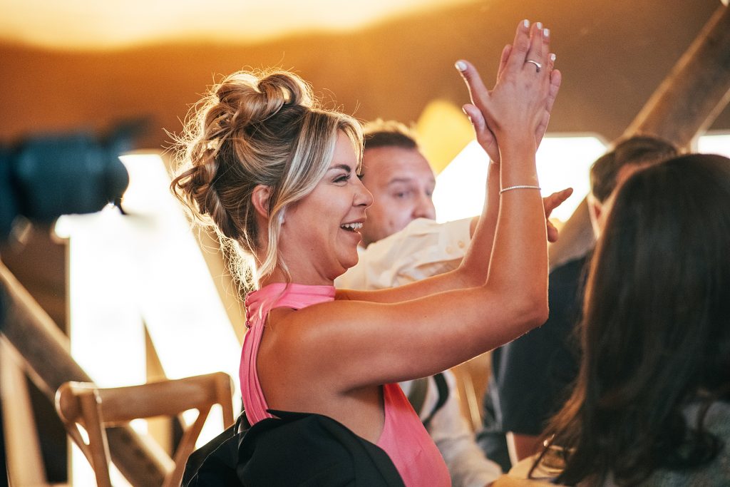guest claps and laughs at speeches in tipi