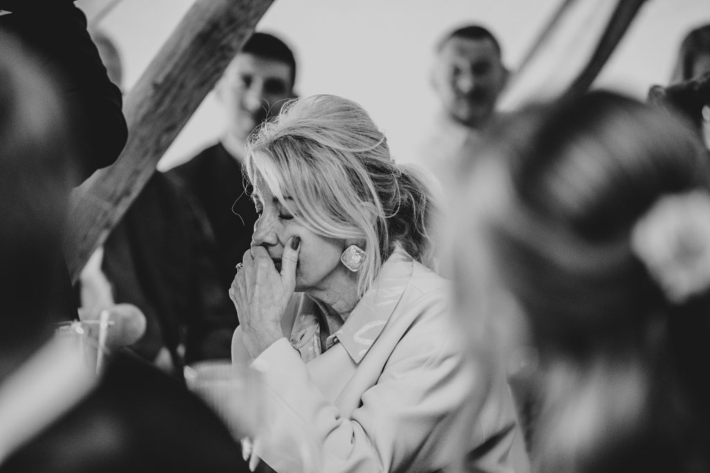 guest covers face at emotional speech in a tipi