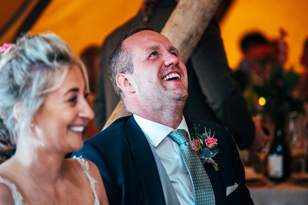 groom laughs and looks up to the sky during best mans speech