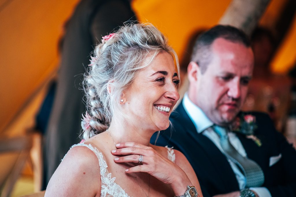 bride laughs at speeches in tipi