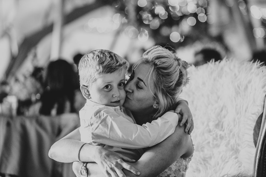 bride kisses her little boy in a tipi