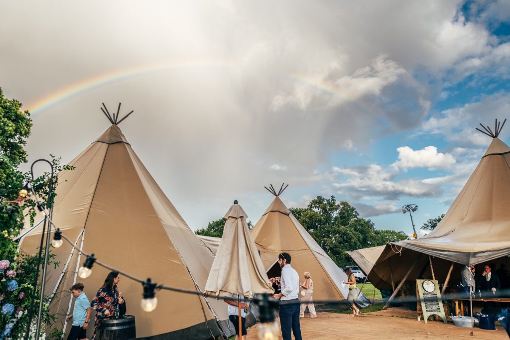 rainbow in the sky over a wedding tipi