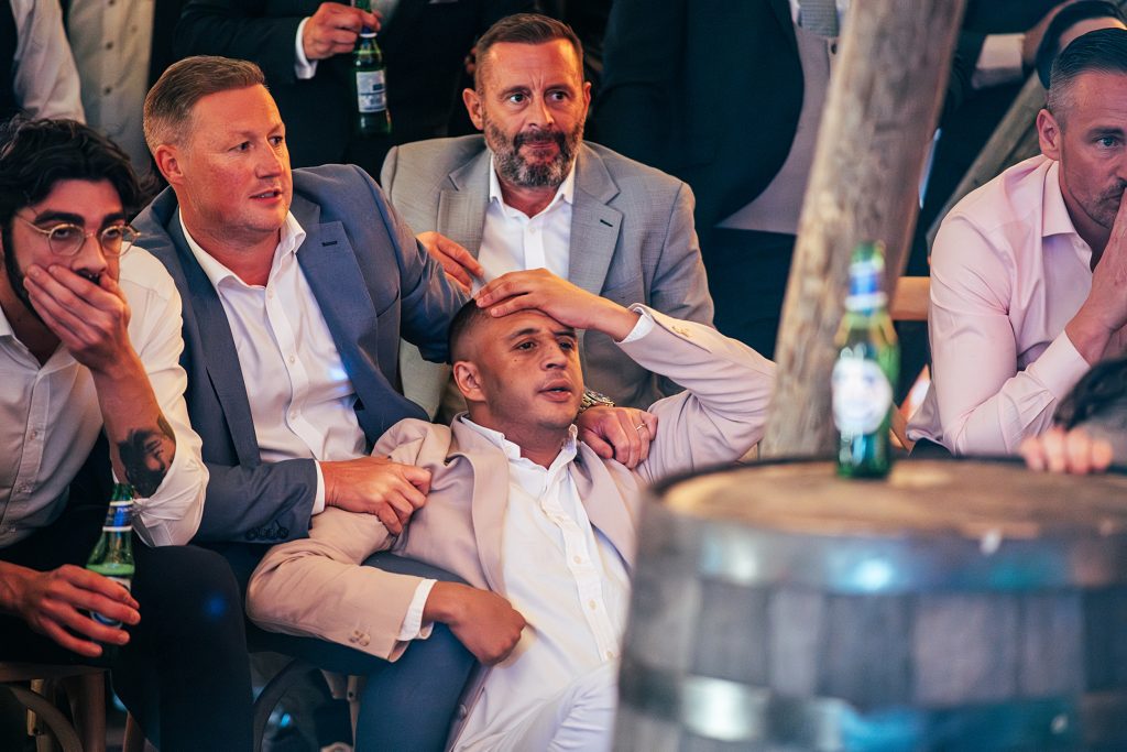 wedding guests hold hands to heads as they watch England take penalties in cup game