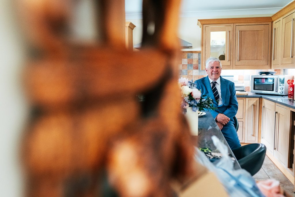 father of bride waits in kitchen before wedding