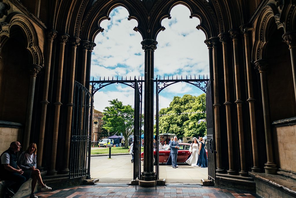 foyer of Ely Cathedral as bride pulls up in her dad's car