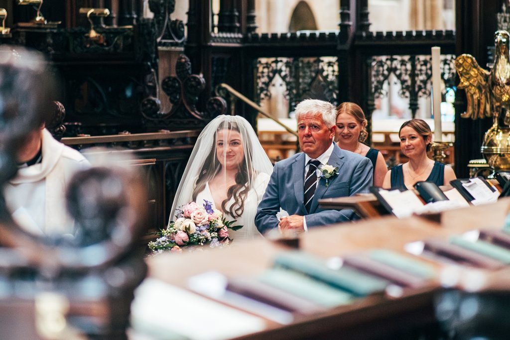 Bride walks up aisle with her dad at Ely Cathedral