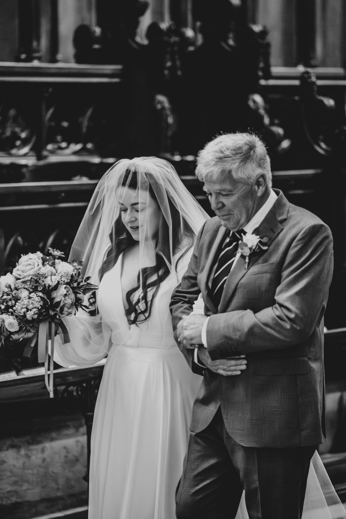 Bride walks down aisle with dad at Ely Cathedral