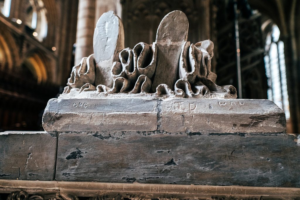 scratched initials in statue at Ely Cathedral