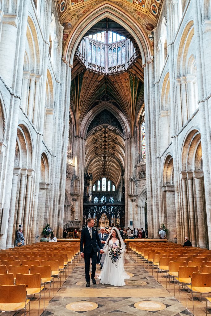 bride and groom walk up aisle at Ely cathedral