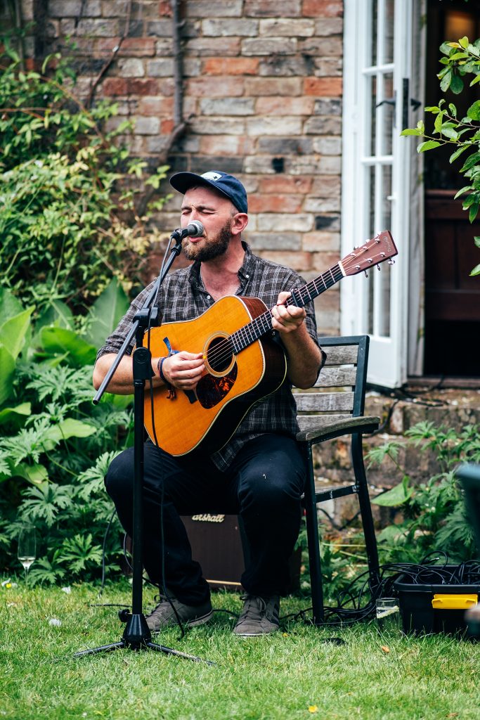 singer with guitar entertains wedding guests