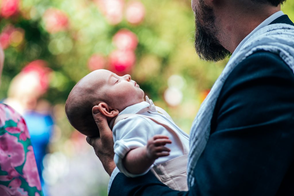 guests holds new baby in garden