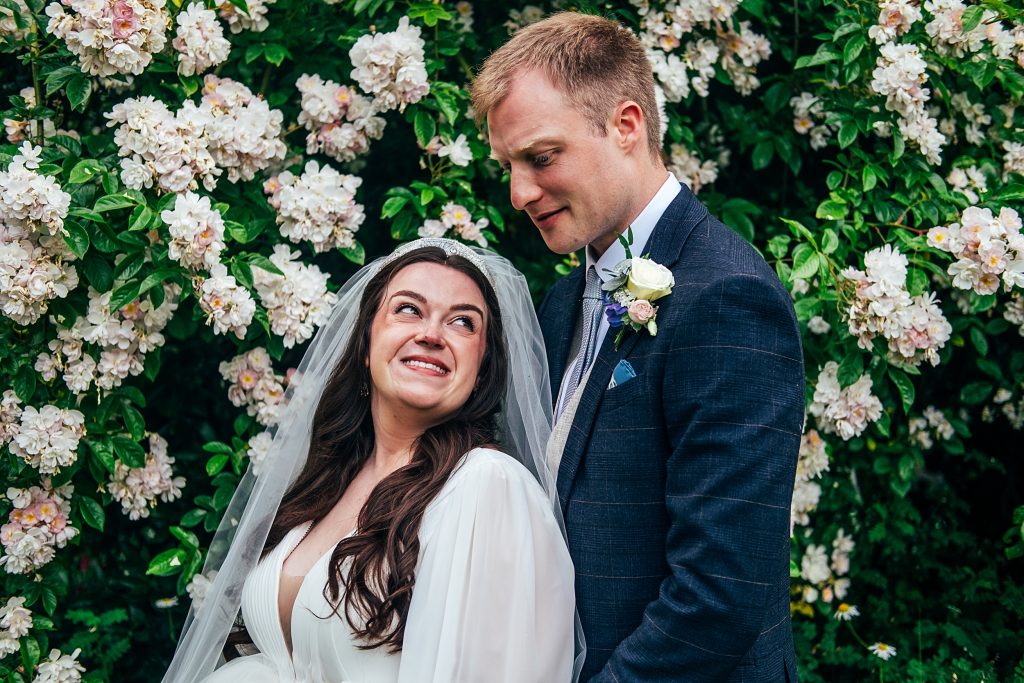 bride and groom in front of blossom tree