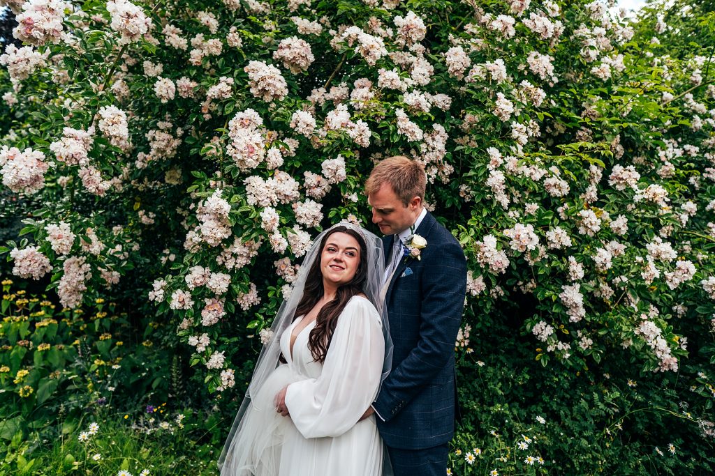 bride and groom in front of blossom tree