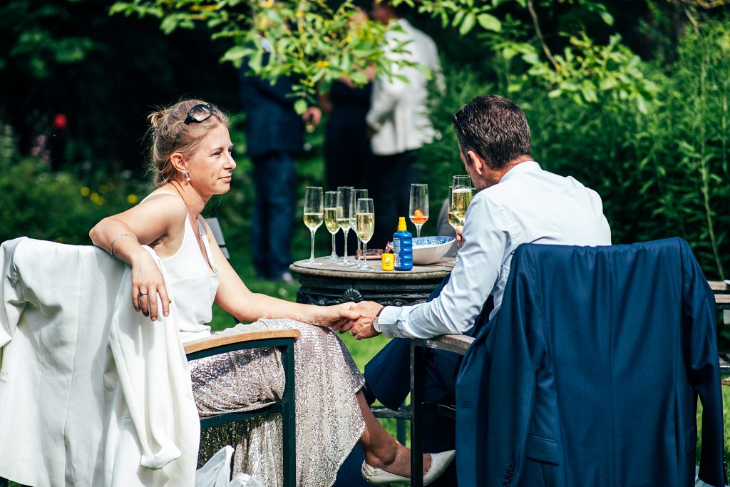 wedding guests sip champagne and hold hands