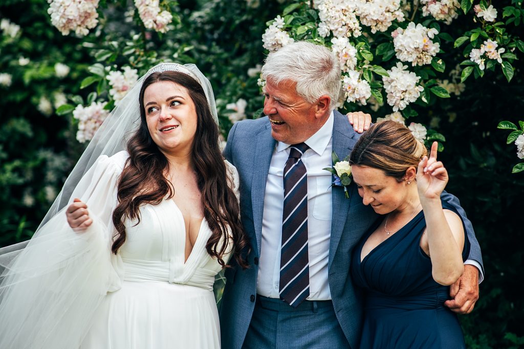 bride hugs her dad and sister