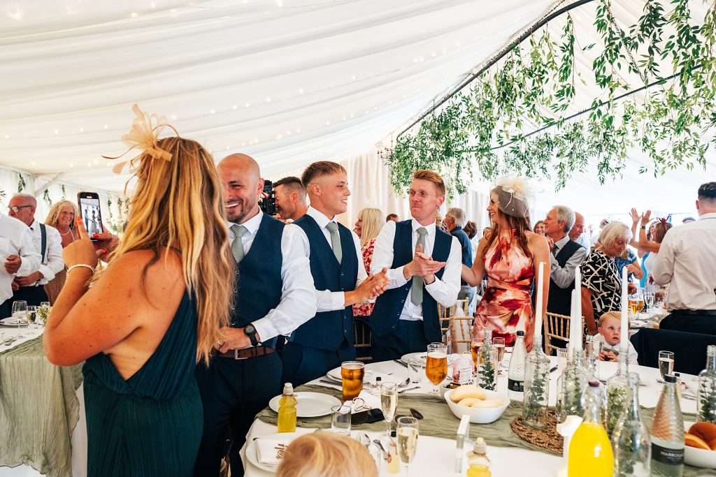 guests clap in marquee