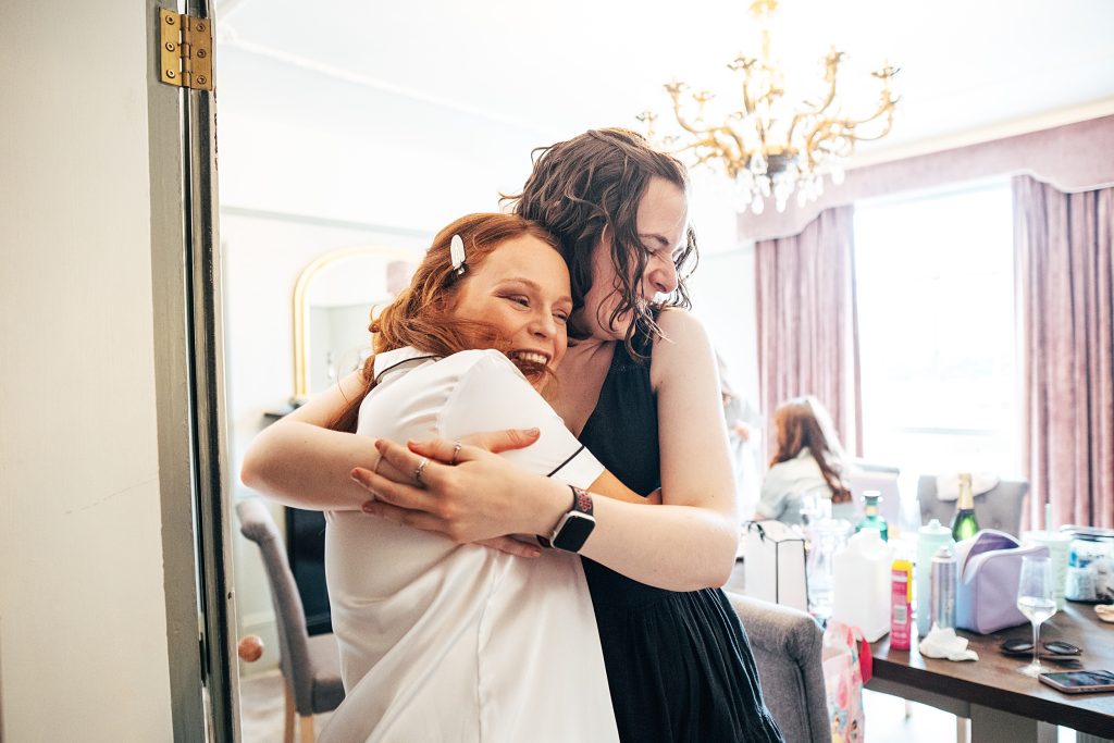 bride hugs friend during prep