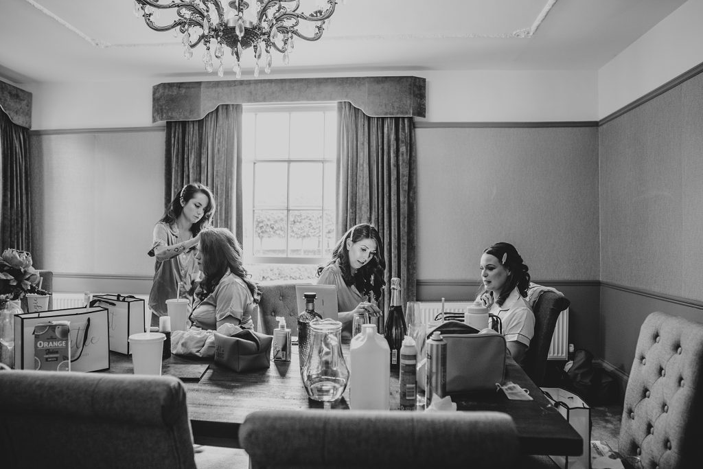 bride and bridesmaids prep round a table