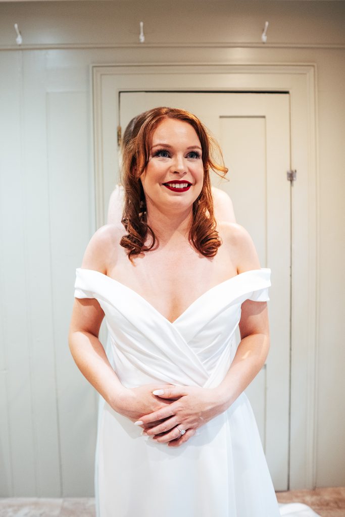 smiling bride as dress done up