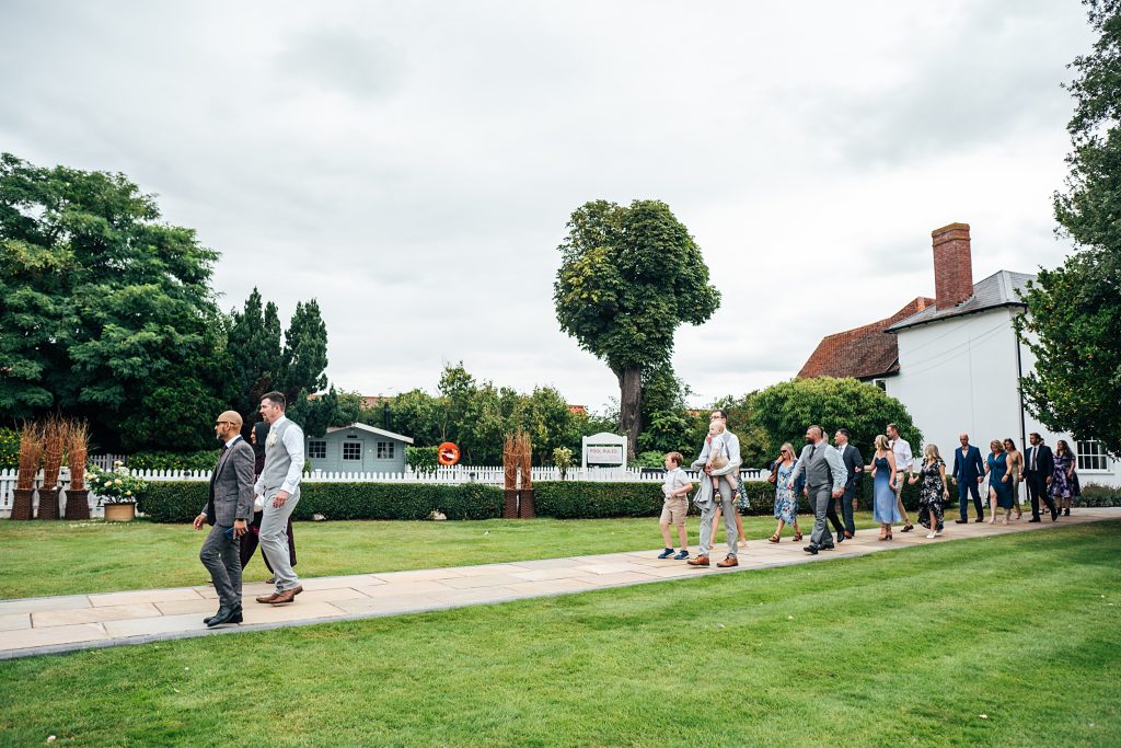 groom leads guests to outdoor ceremony
