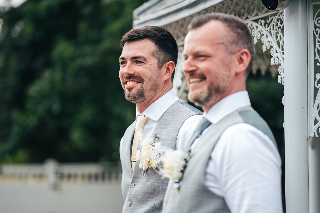 smiling groom waits for bride
