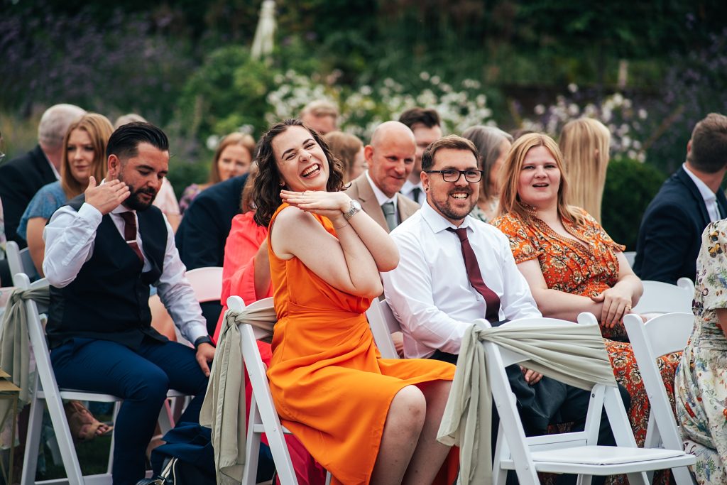 laughing wedding guests wait for bride