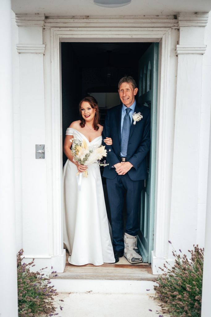 bride and her dad in doorway of white house