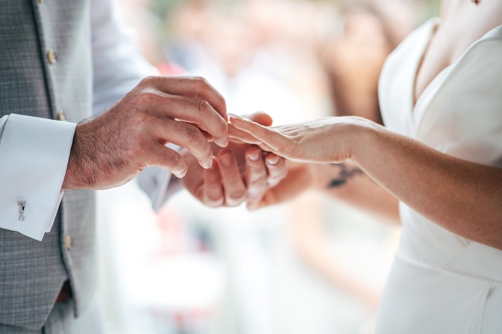 close up of groom placing ring on brides finger