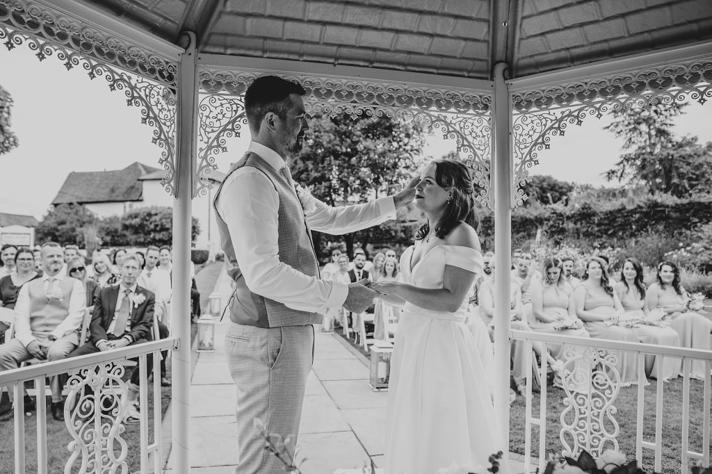 groom strokes brides face during ceremony