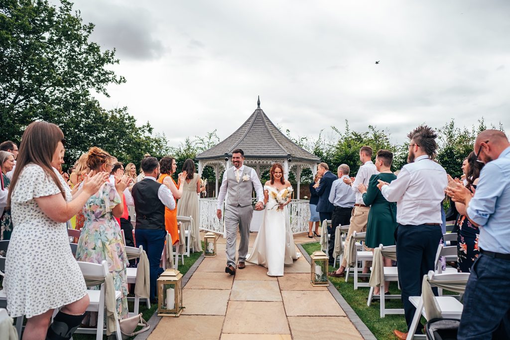 bride and groom walk up aisle