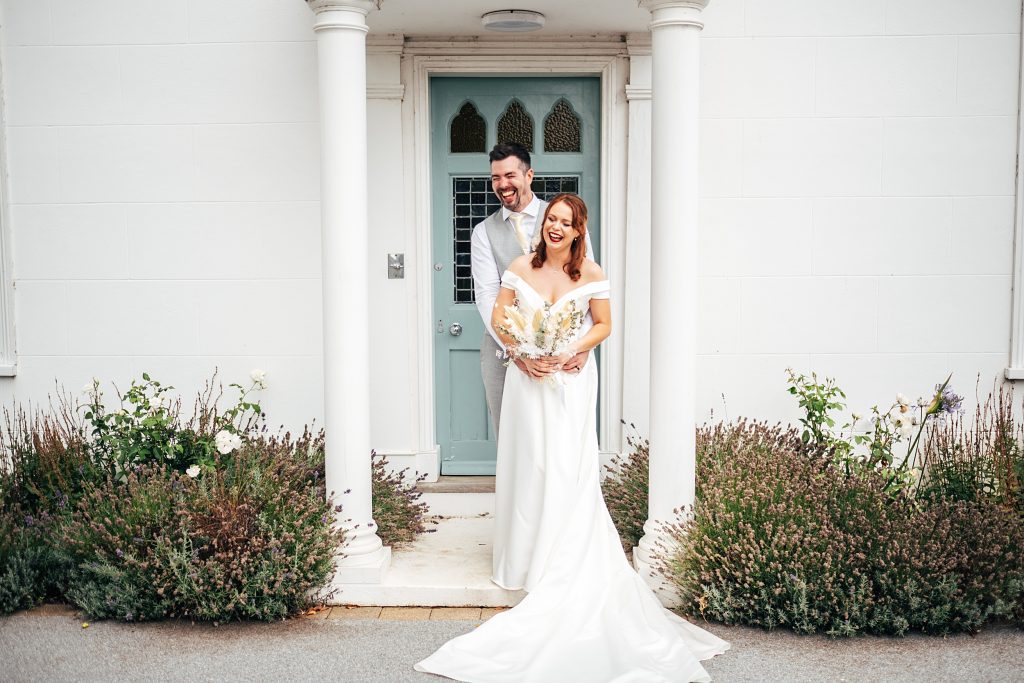 laughing bride and groom on portico of white house