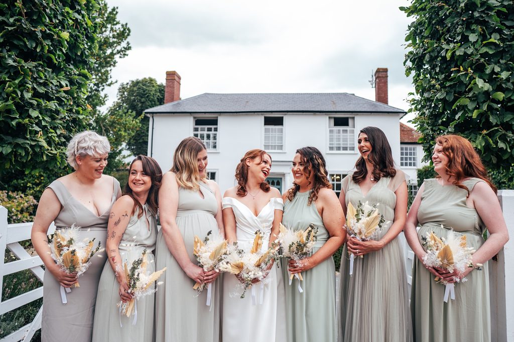 laughing bride and bridesmaids in gateway in front of white house