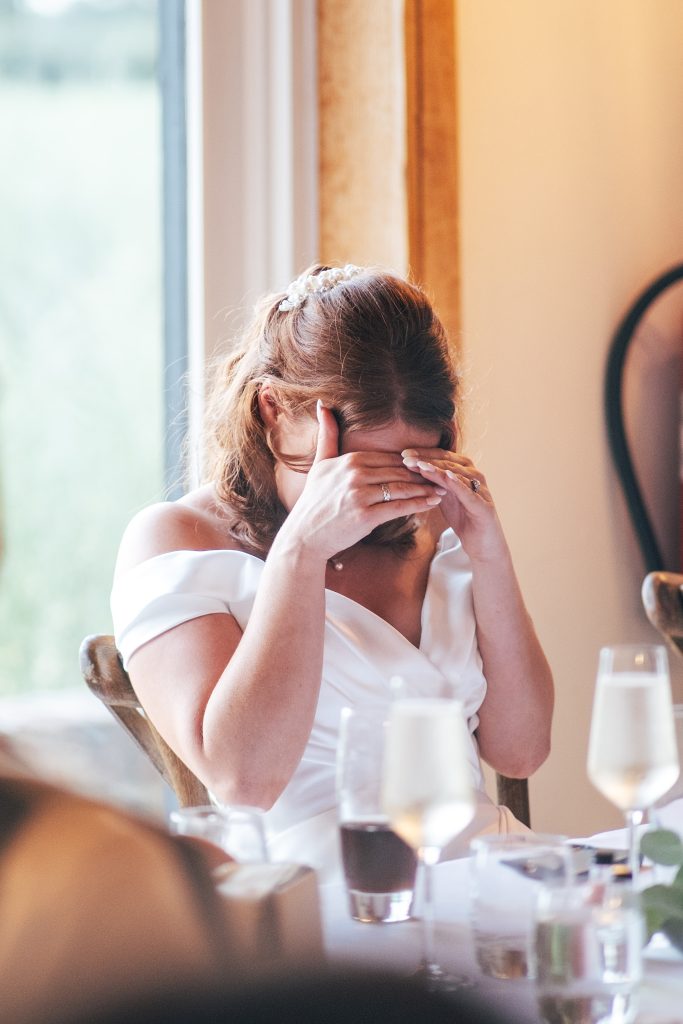 bride covers face during speeches
