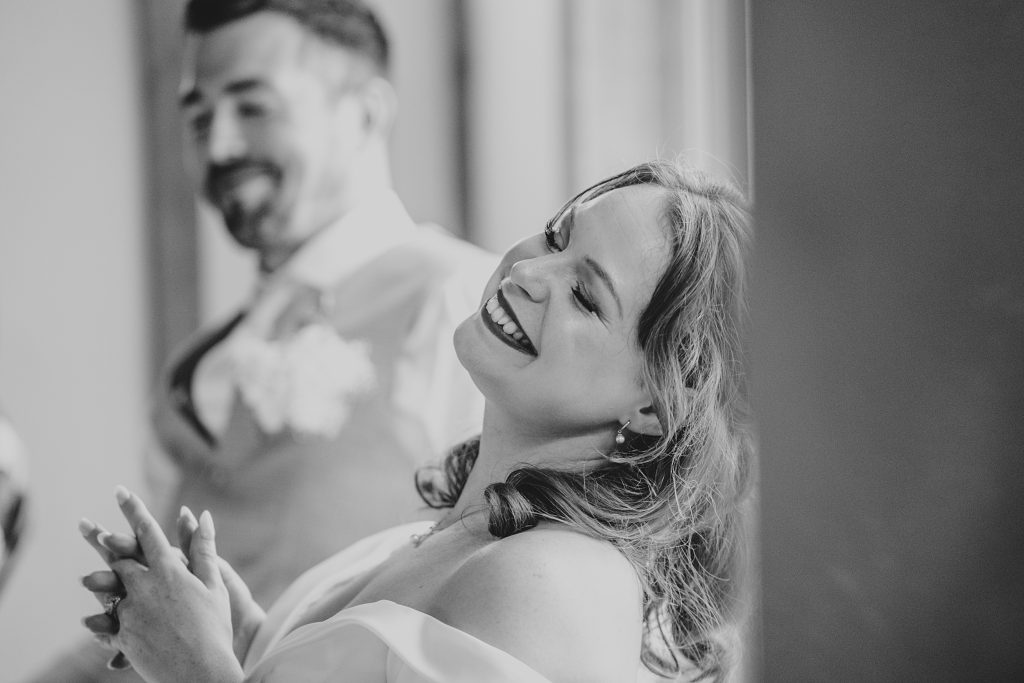 bride leans head back and smiles during speech