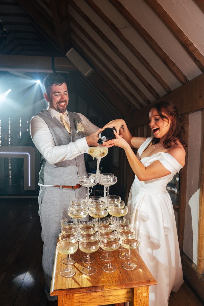 bride and groom pour champagne tower