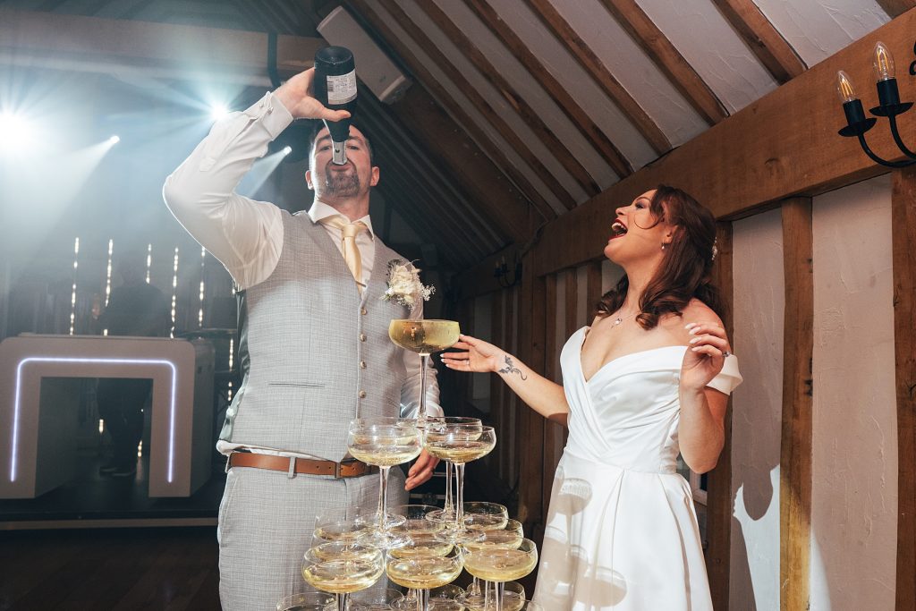bride laughs as groom drinks from champagne bottle