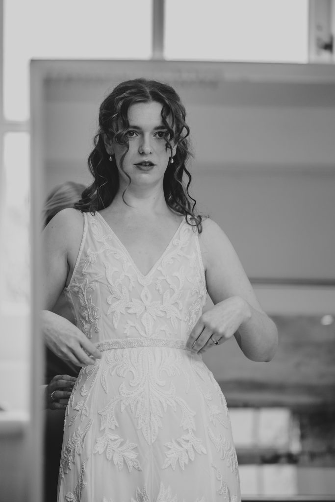 brides reflection in mirror as she has dress done up