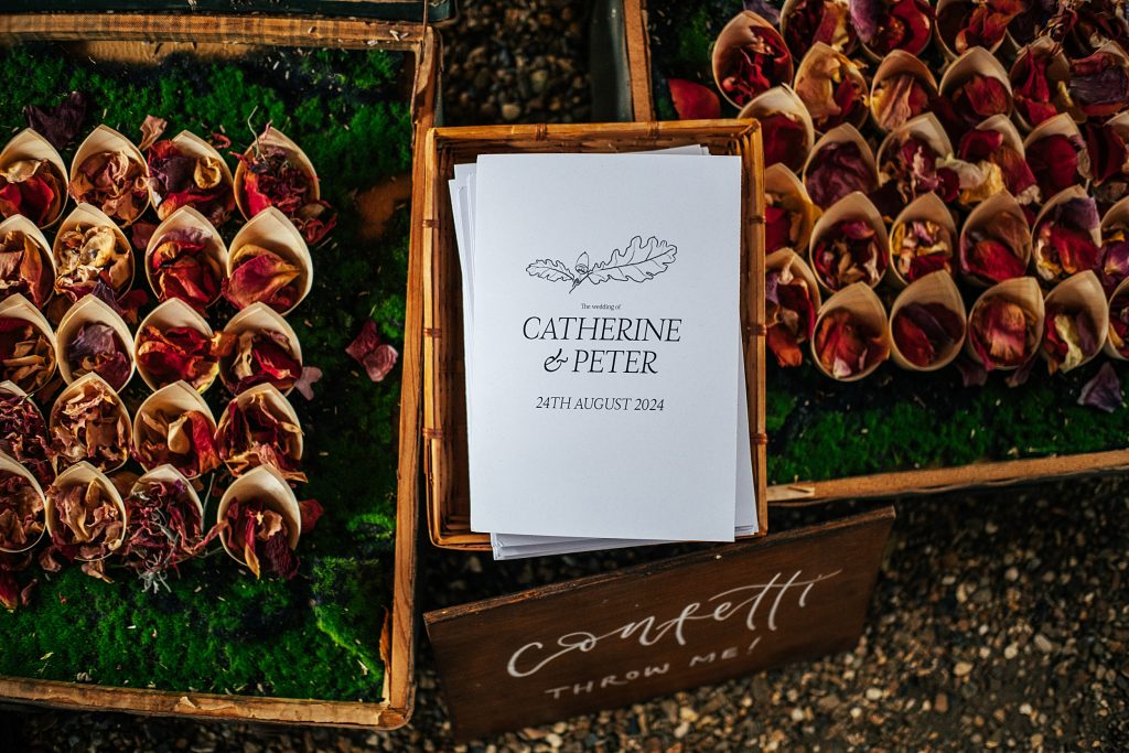 order of service amongst petal confetti in cones