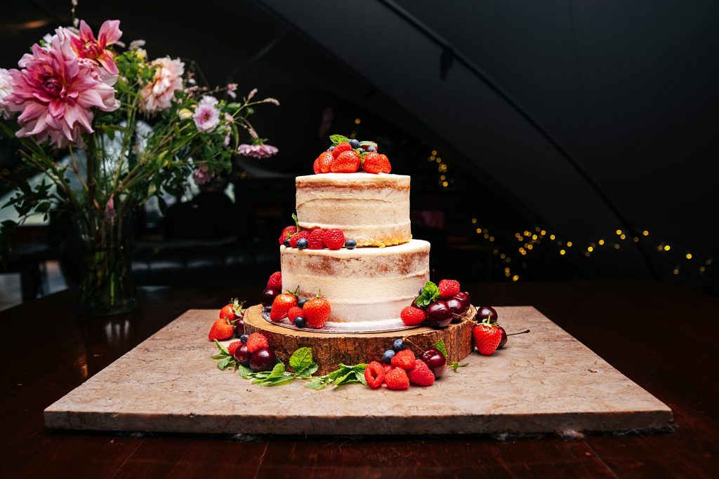 naked wedding cake with strawberries and cherries