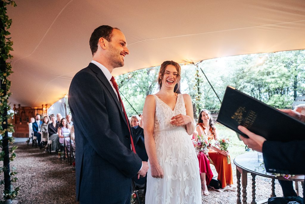bride and groom laugh during wedding ceremony
