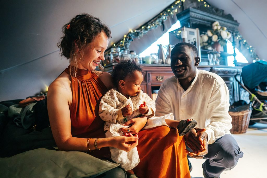 wedding guests laugh and cradle baby on their lap