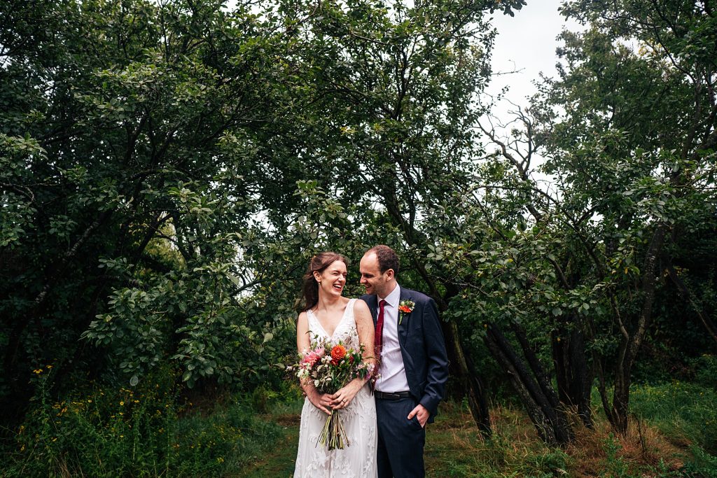 laughing bride and groom in orchard