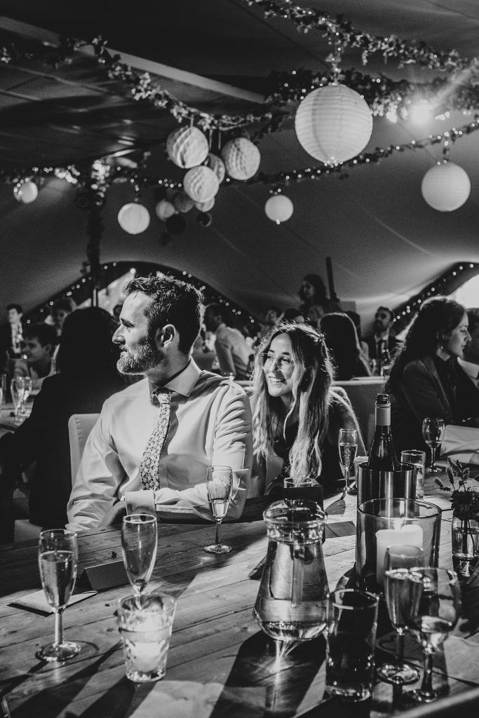 wedding guests listen to speech in stretch tent