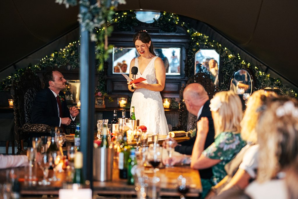 bride gives speech in stretch tent