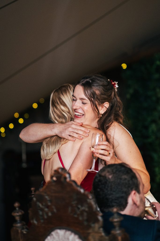 laughing bride hugs her sister