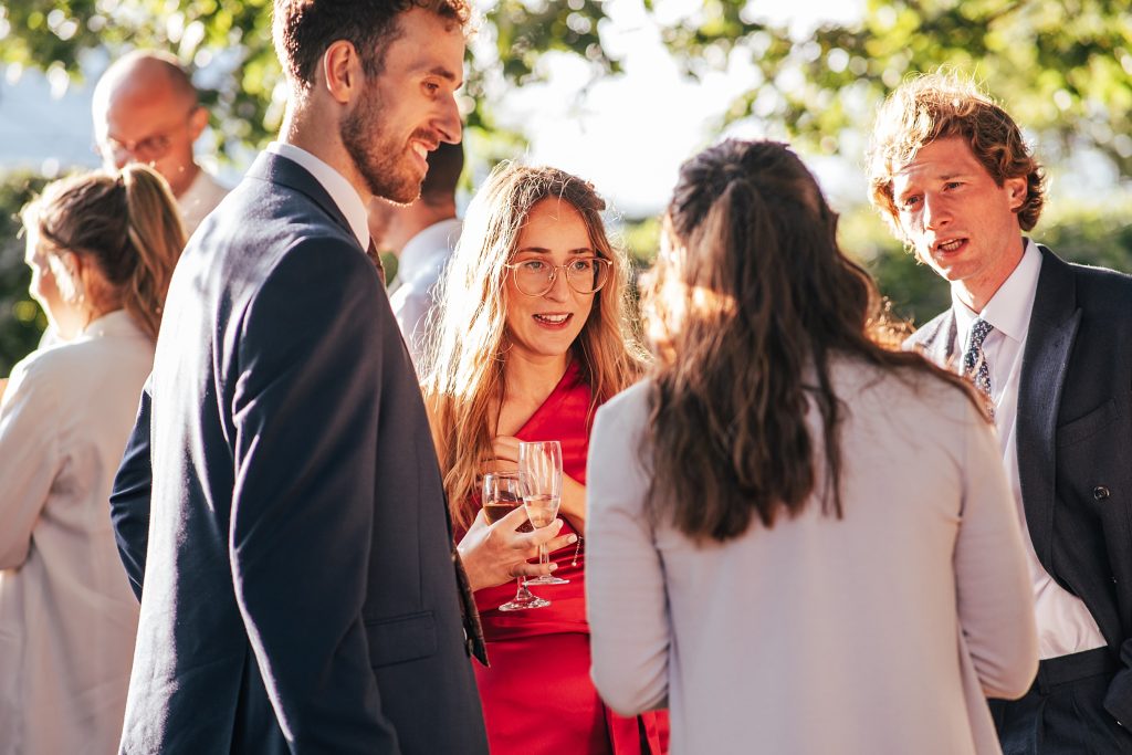 wedding guests mingle in evening sun
