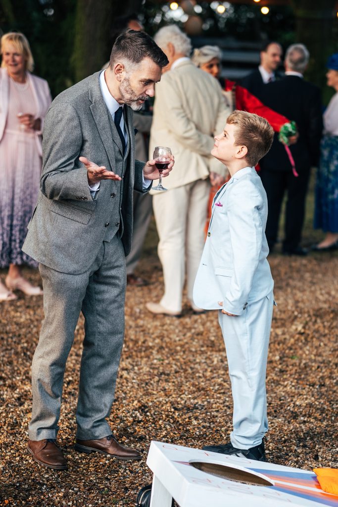 little boy and man holding a wine glass interact